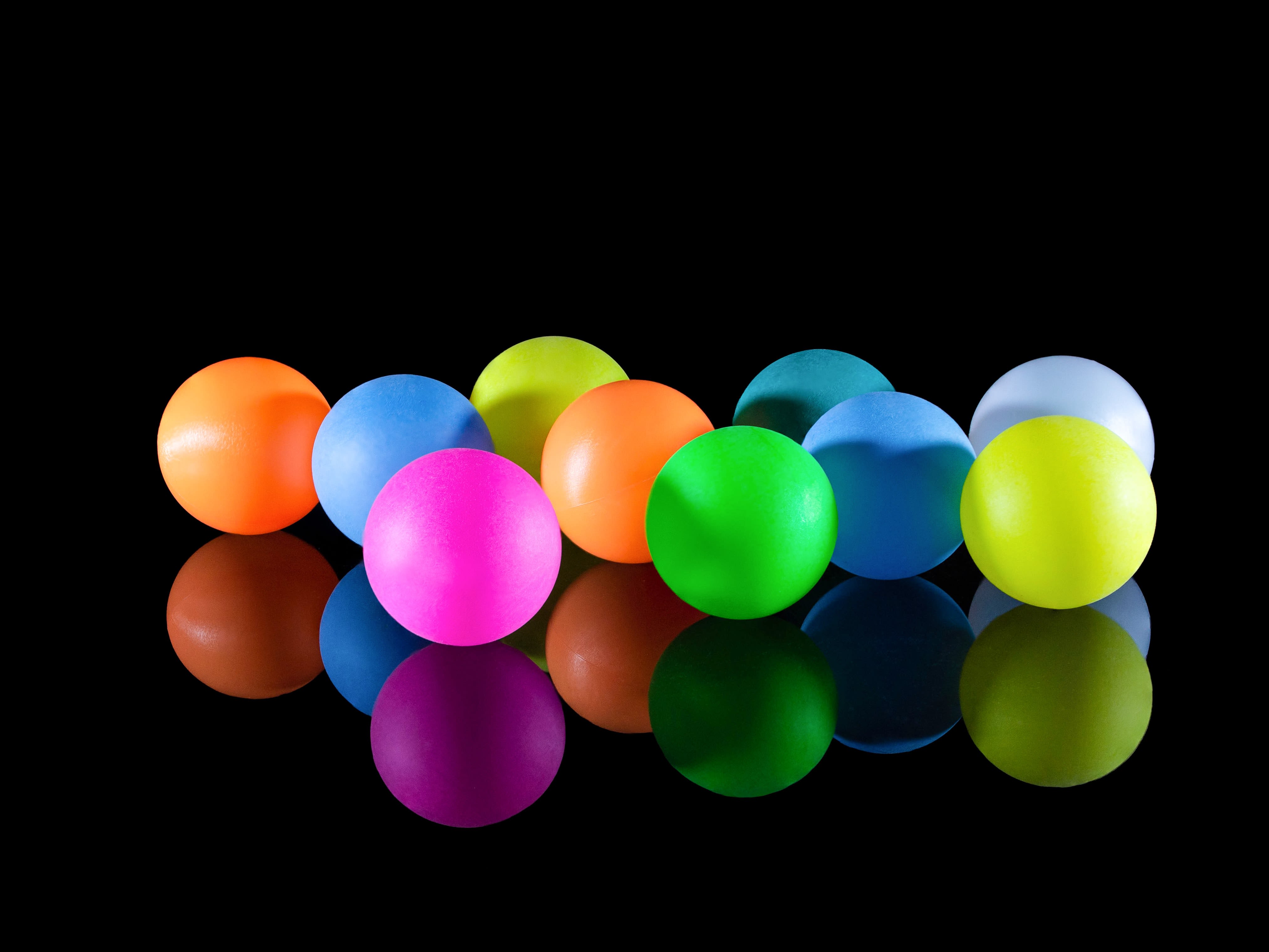 a group of plastic balls sitting on top of a black surface